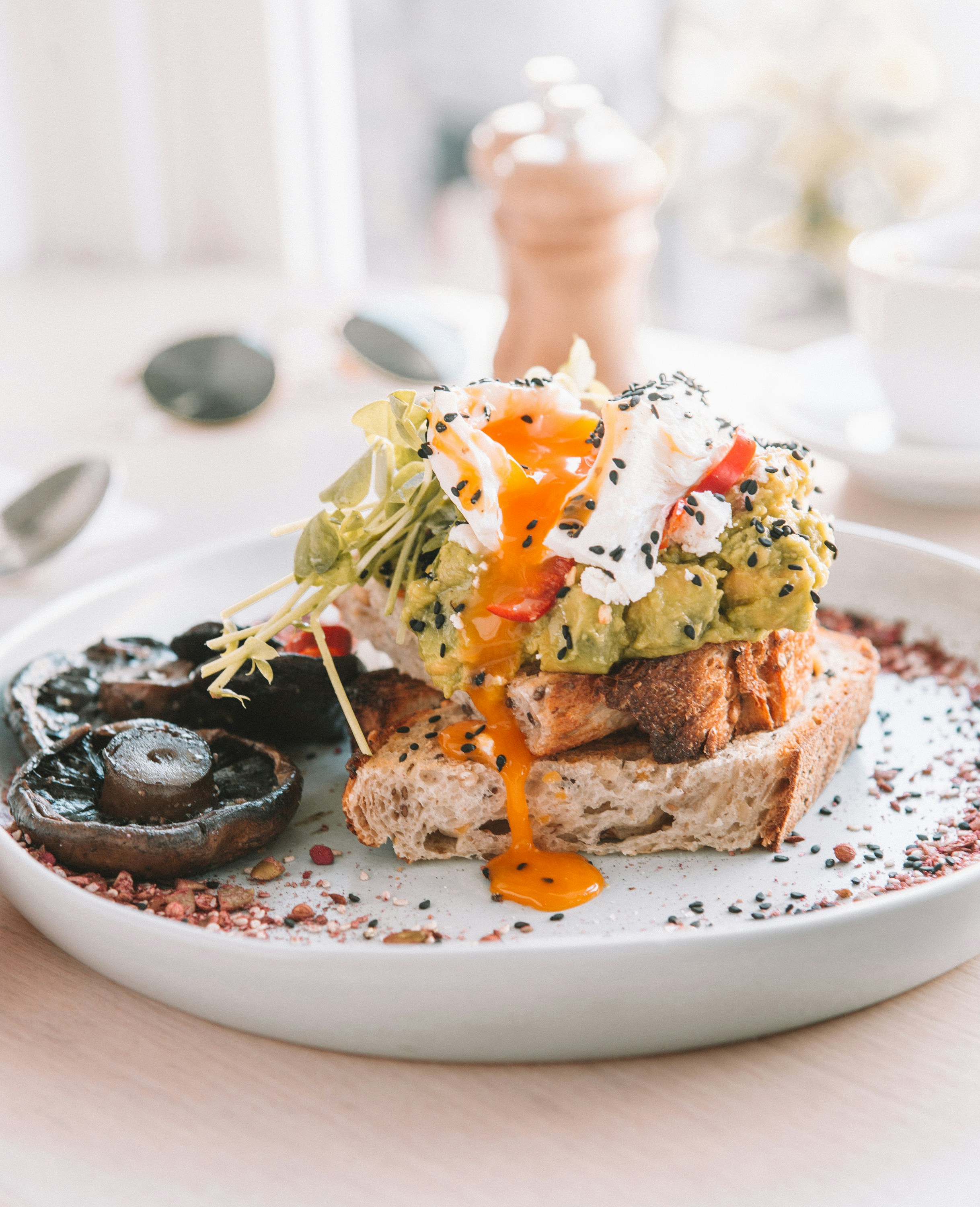 Avocado toast with poached egg, portobello mushroom and black sesame